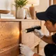 Pest control professional inspecting termite-damaged wooden furniture for signs of infestation.